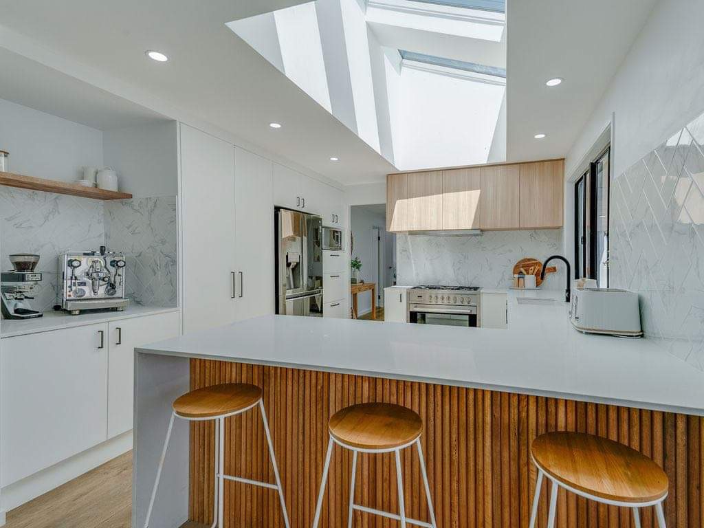 A Veya renovated kitchen with skylights, timber battens and stone benchtops